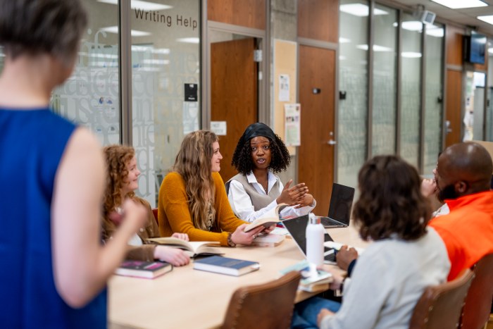 students gathered in a campus meeting room for a collaborative discussion